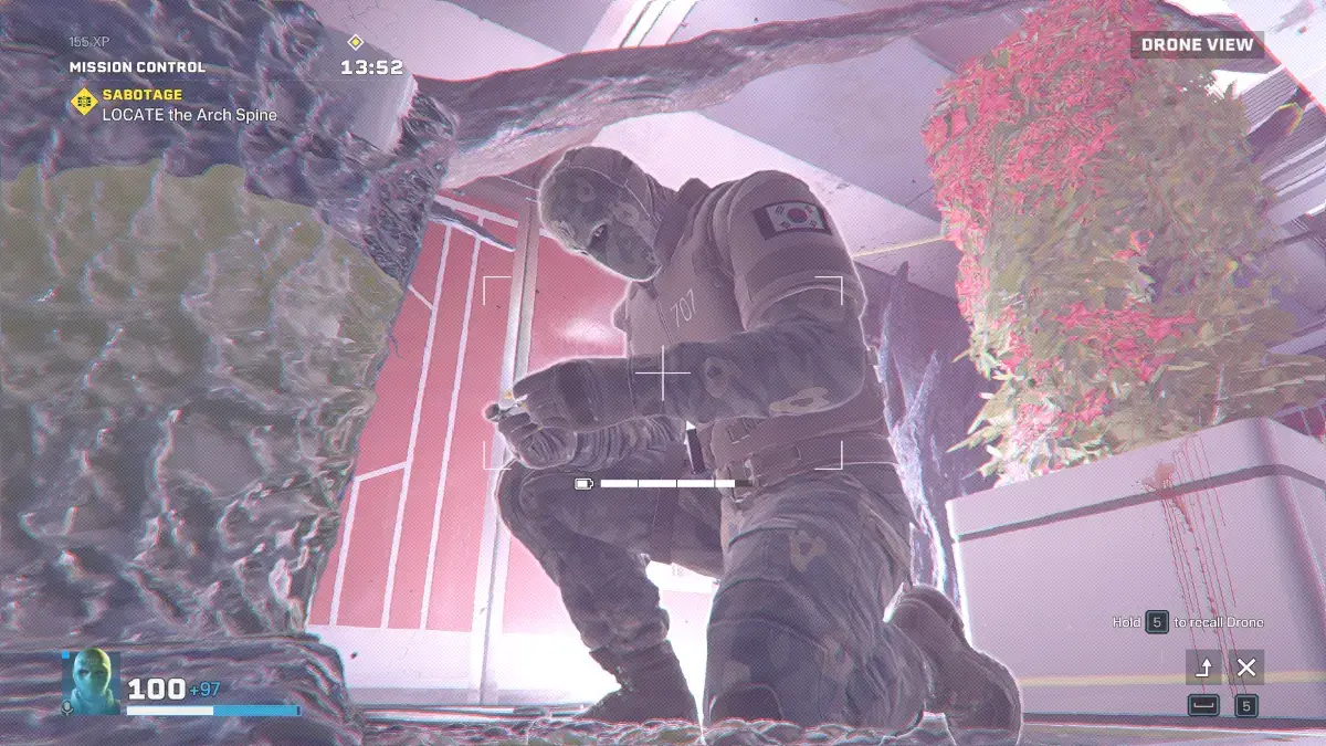 Kadr z gry Rainbow Six Extraction. Operator Vigil wpatrujący się w ekran urządzenia
