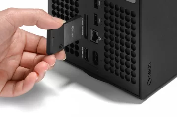 Dłoń wkładająca kartę pamięci Seagate do konsoli Xbox Series X. Tańsza pamięć do xbox.