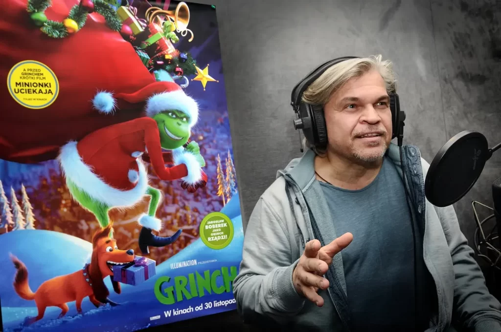 Jarosław Boberek przed mikrofonem w trakcie promocji filmu Grinch