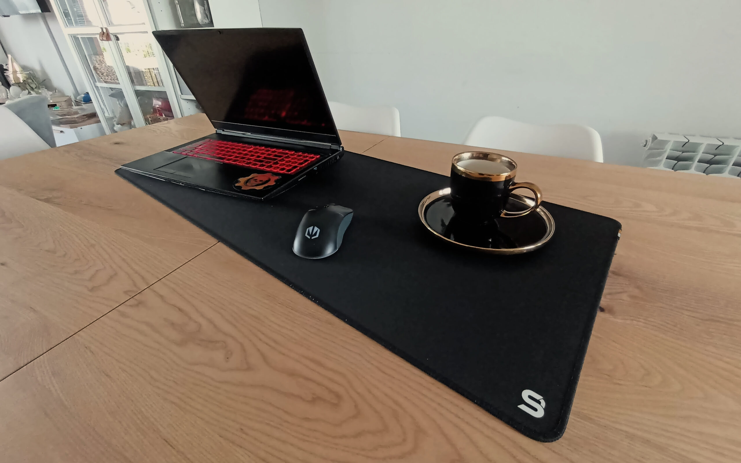 Laptop, myszka i talerzyk z kubkiem kawy stojące na podkładce Cordura Speed XL