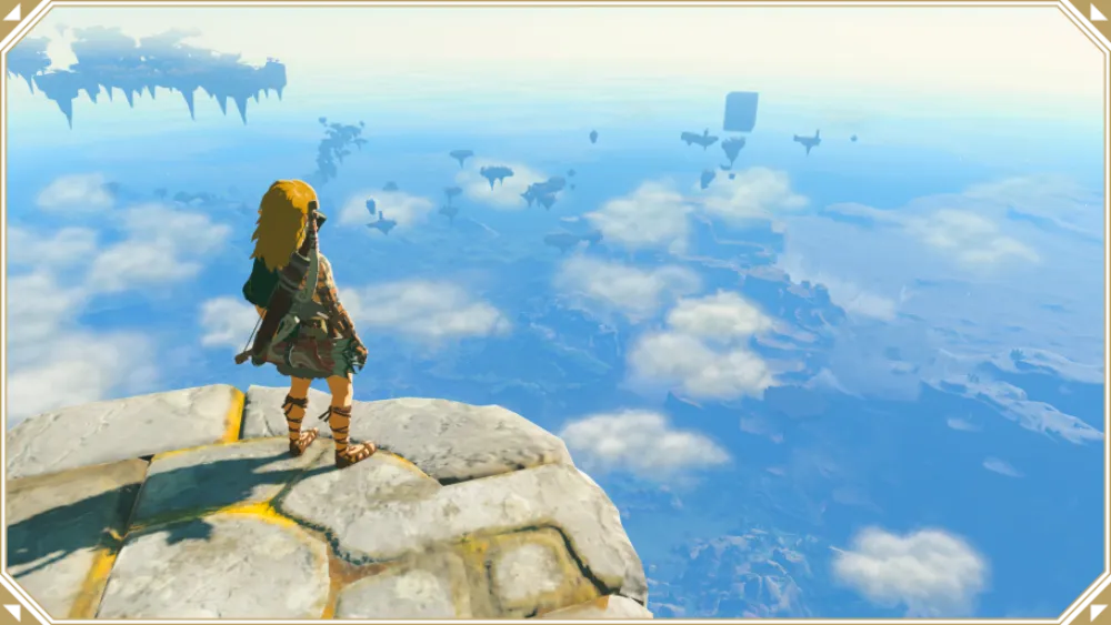 Link stojący na górze i patrzący na panoramę Hyrule skrytą wśród chmur w Tears of the Kingdom