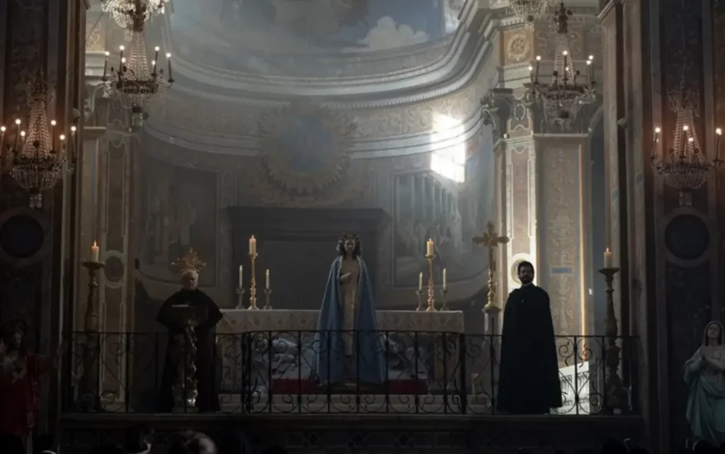 Horror Niepokalana — kadr z filmu. Cecilia w pięknej szacie stojąca tyłem do ołtarza wraz z ojcem wielebnym Sal Tedeschim oraz kardynałem Franco Merolą.