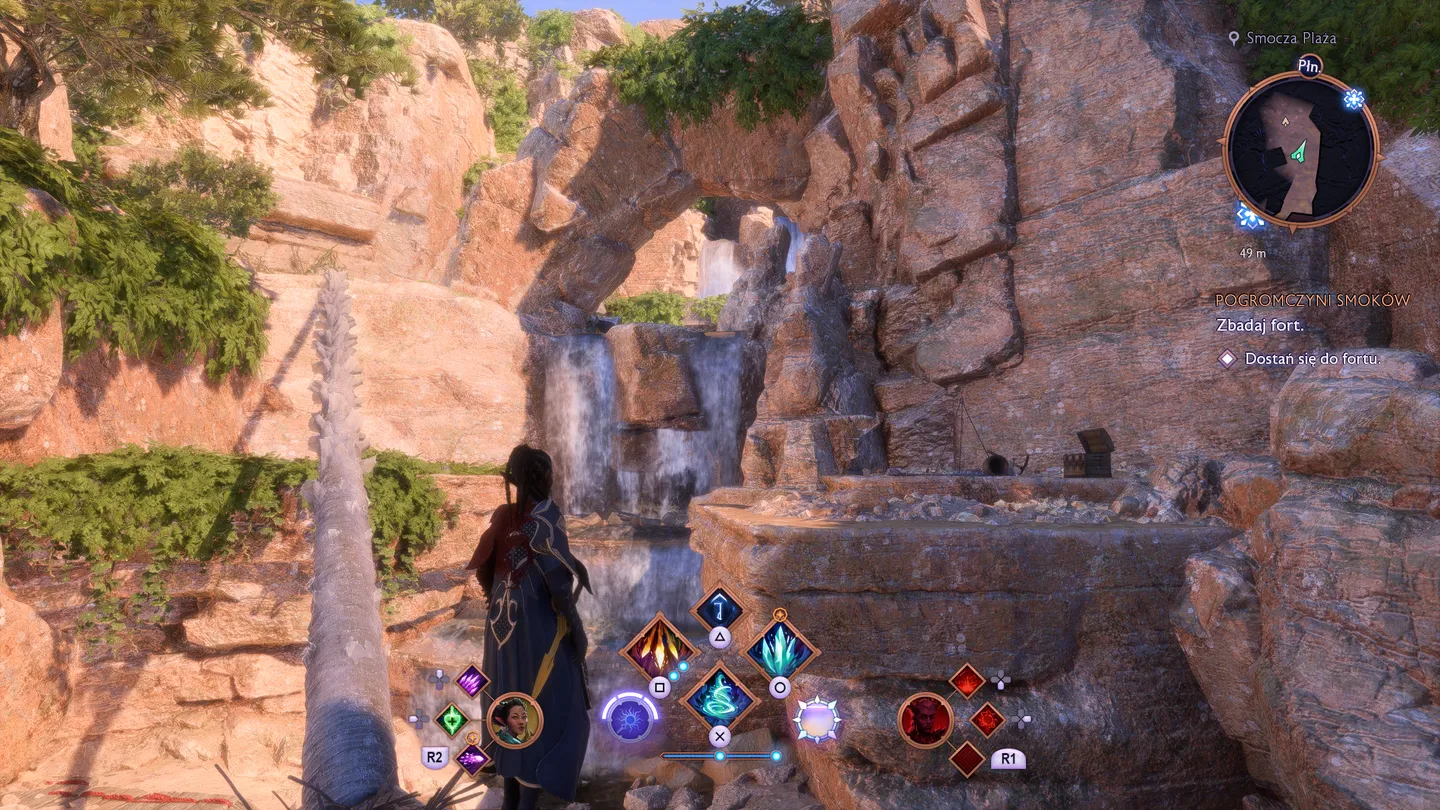 Dragon Age: The Veilguard - malowniczy wodospad w skalnej scenerii Smoczej Plazy. Postać gracza obserwująca krajobraz, w tle misja 'Pogromczyni Smoków'. Interfejs gry z dostępnymi umiejętnościami bojowymi.