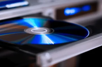 Płyta Blu-ray w napędzie, ukazująca charakterystyczną niebieską powierzchnię nośnika. Zbliżenie na błyszczącą powierzchnię z odbiciami światła.