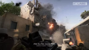 Kadr z nowego Battlefielda, z test&oacute;w Battlefield Labs. Zołnierz z karabinem w perspektywie z pierwszej osoby, przed nim piętrowy, piaskowy budynek, w kt&oacute;rym nastąpiła eksplozja i część&nbsp;ściany leci na ziemię.