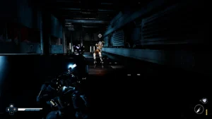 Ciemny, futurystyczny korytarz przemysłowy; w centrum zbliżający się robot przeciwnik, po lewej stronie postać gracza ukryta za osłoną, z podświetlonym na niebiesko ramieniem i interfejsem gry widocznym w rogu ekranu