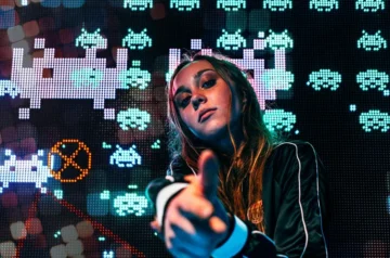 Kobieta wskazująca w kamerę na tle Space Invaders