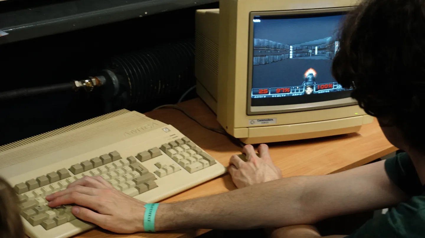 Entuzjasta retro gamingu gra w kultową strzelankę DOOM na komputerze Amiga, korzystając z oryginalnego monitora Commodore. Atmosfera klasycznych lat 90. na festiwalu Pixel Heaven 2025
