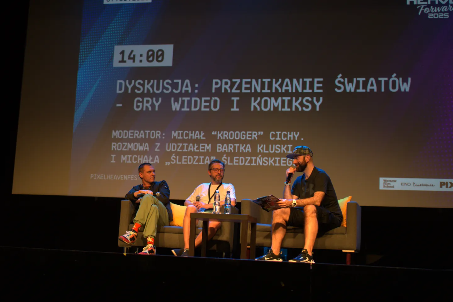 Panel dyskusyjny podczas Pixel Heaven 2025 na temat przenikania się świat&oacute;w gier wideo i komiks&oacute;w. Na scenie trzech prelegent&oacute;w rozmawia o związkach popkultury, a w tle widoczna jest plansza z tematem i nazwiskami uczestnik&oacute;w.