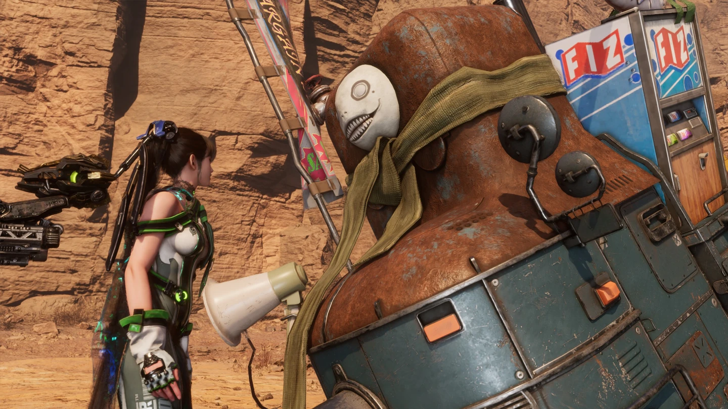 Bohaterka Eve stoi obok dużego, zardzewiałego robota z charakterystyczną maską.