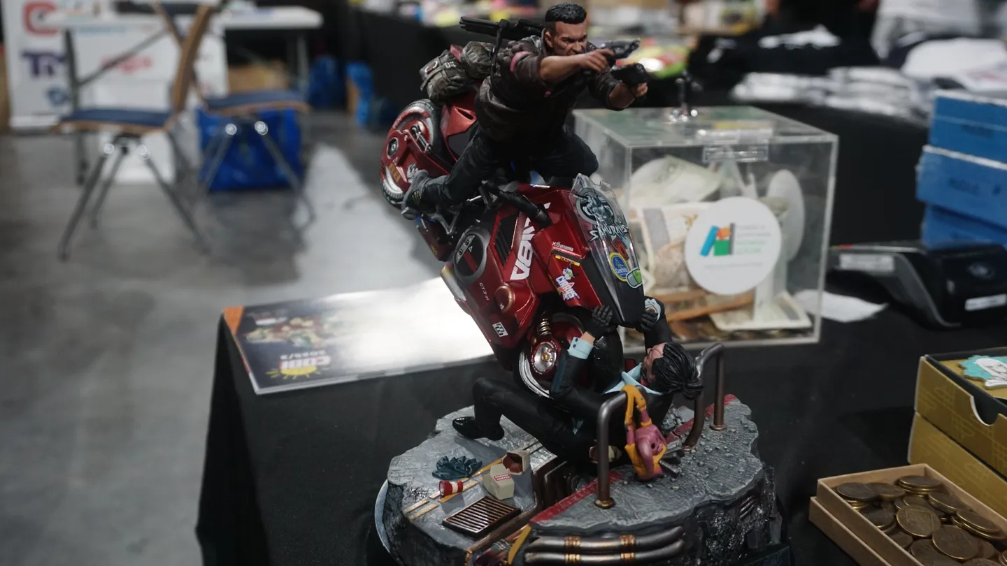 Detal kolekcjonerskiej figurki z motywem gry akcji na stoisku CD-Action EXPO 2025. Dynamiczna scena z motocyklem przyciąga uwagę fan&oacute;w popkultury oraz kolekcjoner&oacute;w gadżet&oacute;w gamingowych podczas konwentu.