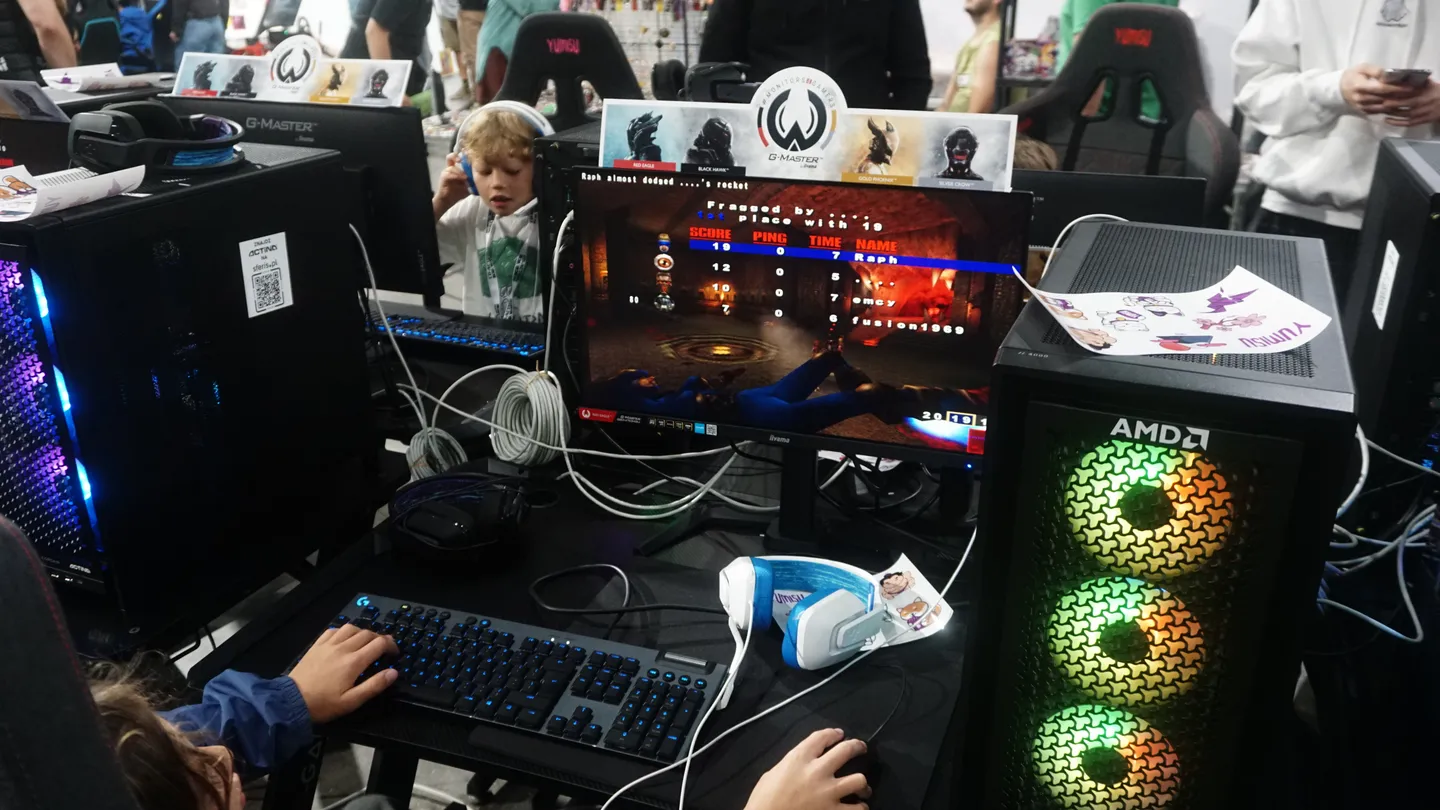 Turniej FPS na nowoczesnych komputerach gamingowych w strefie G-Master podczas CD-Action EXPO 2025. Uczestnicy rywalizują przy komputerach z procesorami AMD, testując sprzęt oraz najnowsze gry w rozgrywkach esportowych.