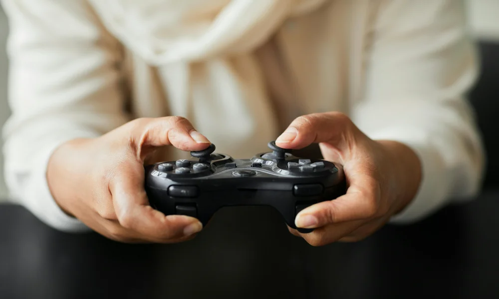 Kobiece dłonie obejmujące kontroler do Xbox