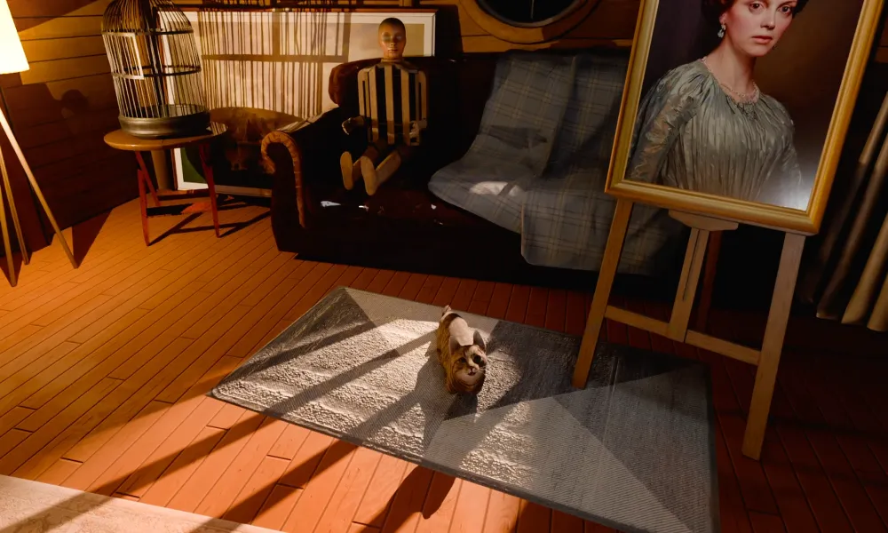 Wnętrze strychu w The 18th Attic – kot leżący na dywanie, manekin siedzący na fotelu oraz portret kobiety ustawiony na sztaludze