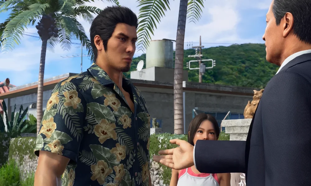 Scena dialogowa z Yakuza Kiwami 3 and Dark Ties przedstawiająca Kazumę Kiryu w hawajskiej koszuli podczas rozmowy z inną postacią na tle miejskiej dzielnicy.