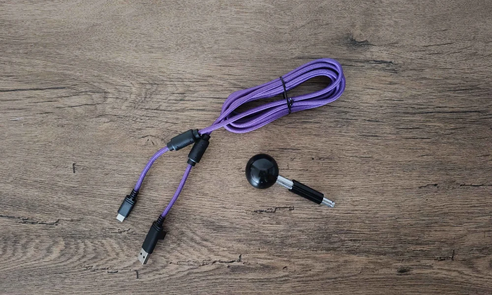Fioletowy przewód USB-C z blokadą oraz wymienny joystick ball-top do Victrix Pro FS na drewnianym blacie.