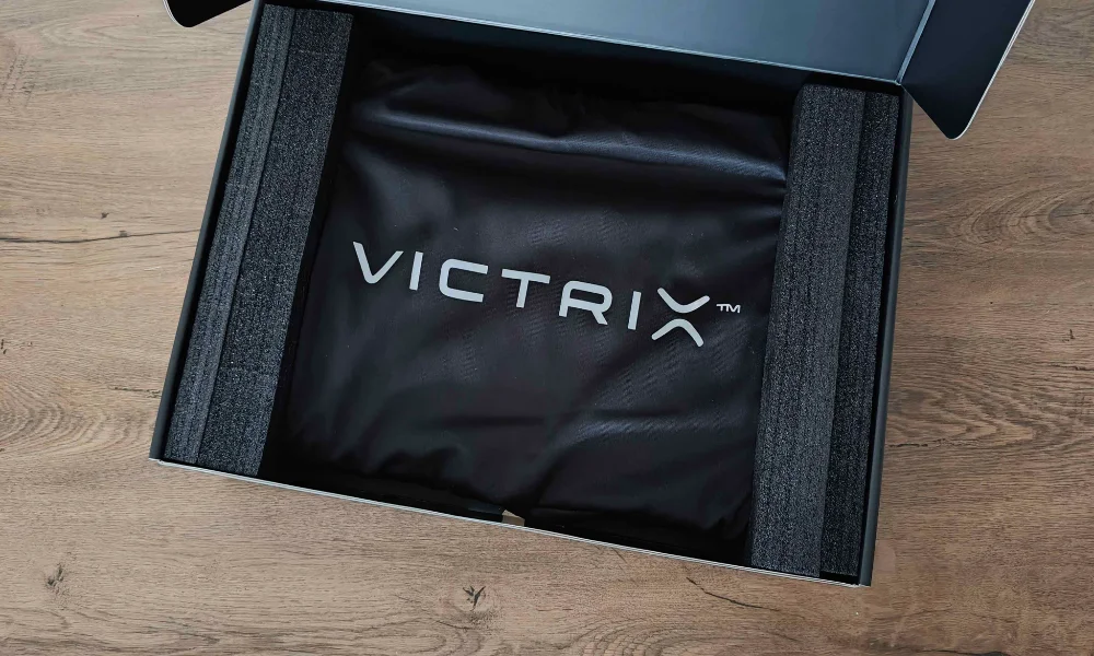 Otwarty karton Victrix Pro FS z piankowym zabezpieczeniem i pokrowcem z logo Victrix.