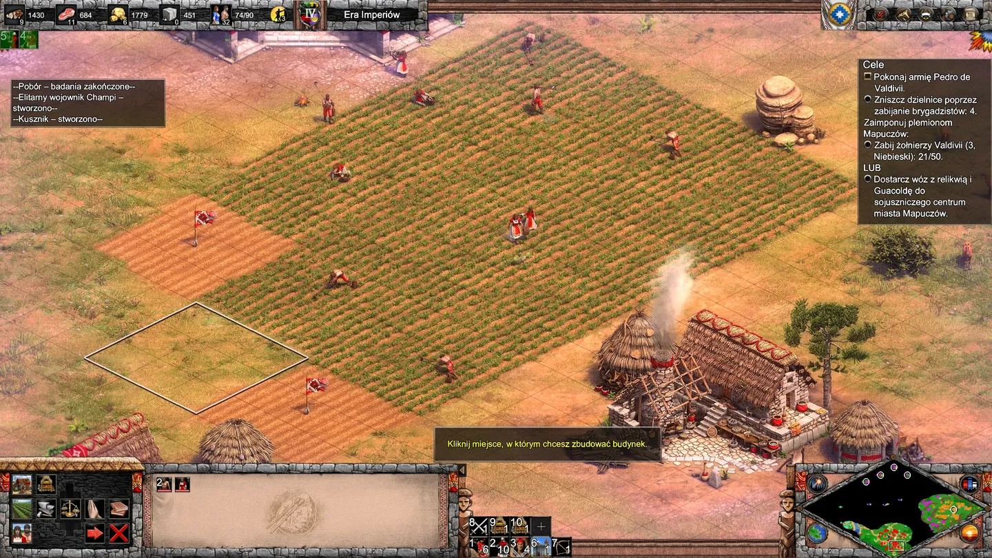 Widok z g&oacute;ry na mapę Celt&oacute;w w Age of Empires II: Definitive Edition &ndash; The Last Chieftains: armia w formacji na zielonej r&oacute;wninie z polami pszenicy, chatami i dymem z ognisk, interfejs z minimapą i danymi o jednostkach. ​ ​ ​