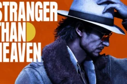 Grafika z napisem „Stranger Than Heaven” przedstawiająca mężczyznę w fedorze, okularach przeciwsłonecznych i płaszczu z futrzanym kołnierzem na pomarańczowym tle.