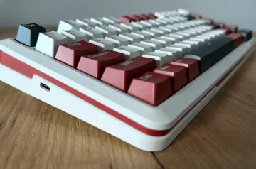 Lewy bok klawiatury Redragon Stormhunter na drewnianym blacie.