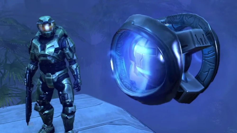 Master Chief stojący przed metalową kulą ze świecącymi na niebiesko elementami