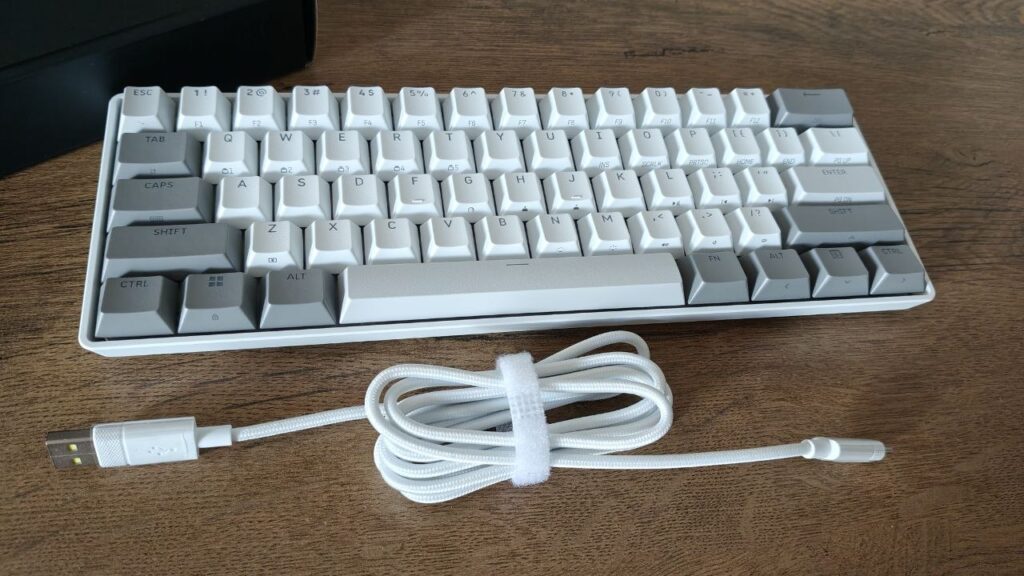 Kompaktowa klawiatura Corsair Clipper Pro Mini 60 w biało-szarej kolorystyce wraz z dołączonym, białym kablem USB w oplocie.
