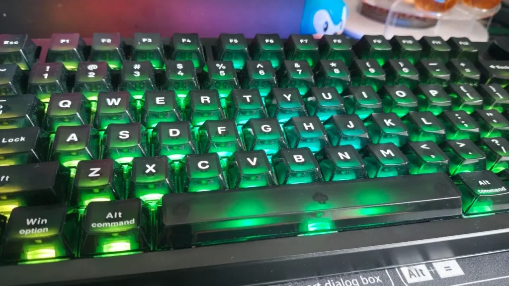 Klawisze z profilowanymi nakładkami i jasnym, zielonym podświetleniem RGB od dołu przełączników.