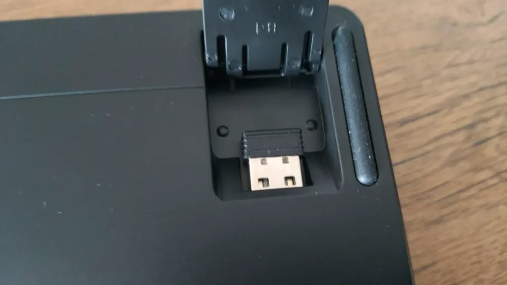Schowek na bezprzewodowy odbiornik USB 2.4 GHz umieszczony pod rozkładaną nóżką klawiatury.