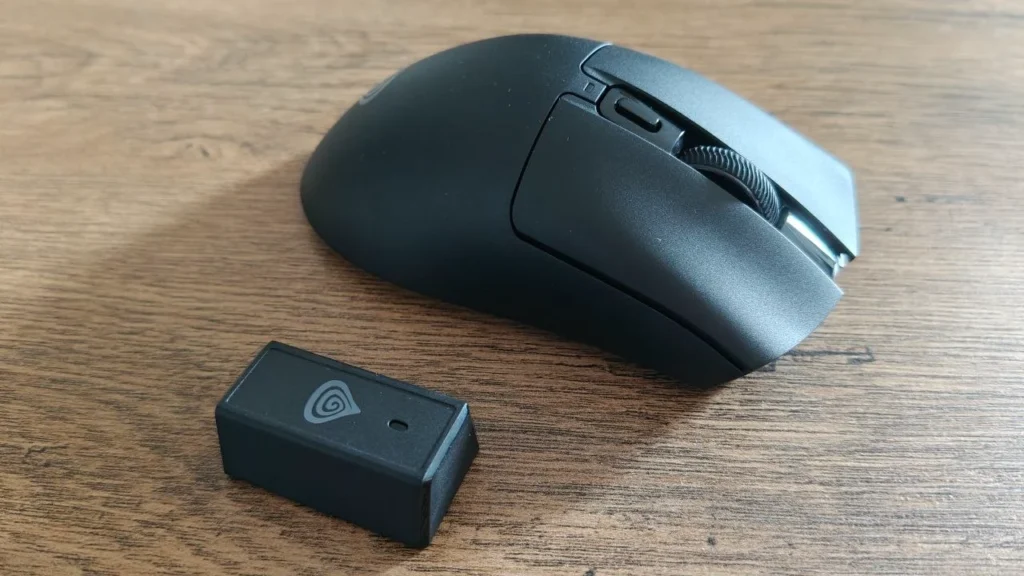 Czarna ergonomiczna mysz gamingowa Zircon 880 Pro na drewnianym biurku, widok z boku. Widoczne dwa przyciski boczne, rolka przewijania, dodatkowy przycisk nad rolką oraz oznaczenie „ZIRCON 880 PRO” na obudowie.