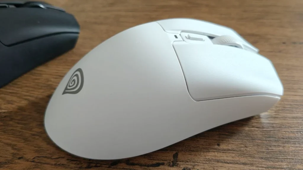 Biała ergonomiczna mysz gamingowa Zircon 880 Pro na drewnianym biurku, widok z boku. Widoczne dwa przyciski boczne, rolka przewijania, dodatkowy przycisk nad rolką oraz oznaczenie „ZIRCON 880 PRO” na obudowie.