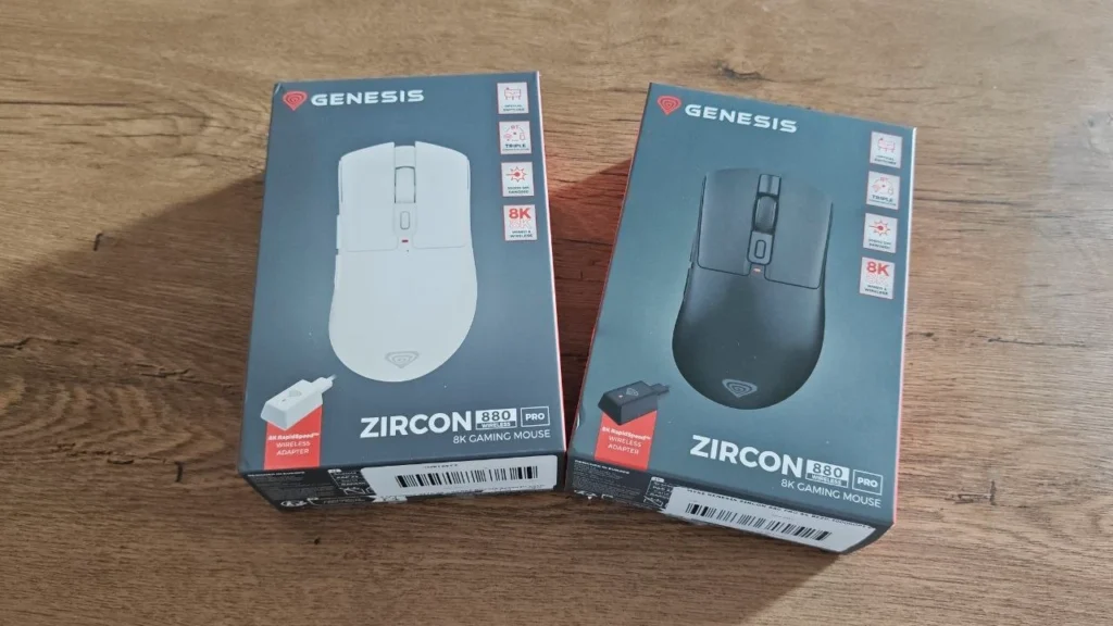 Dwa pudełka myszy Genesis Zircon 880 Pro — czarnej i białej — na drewnianym biurku.