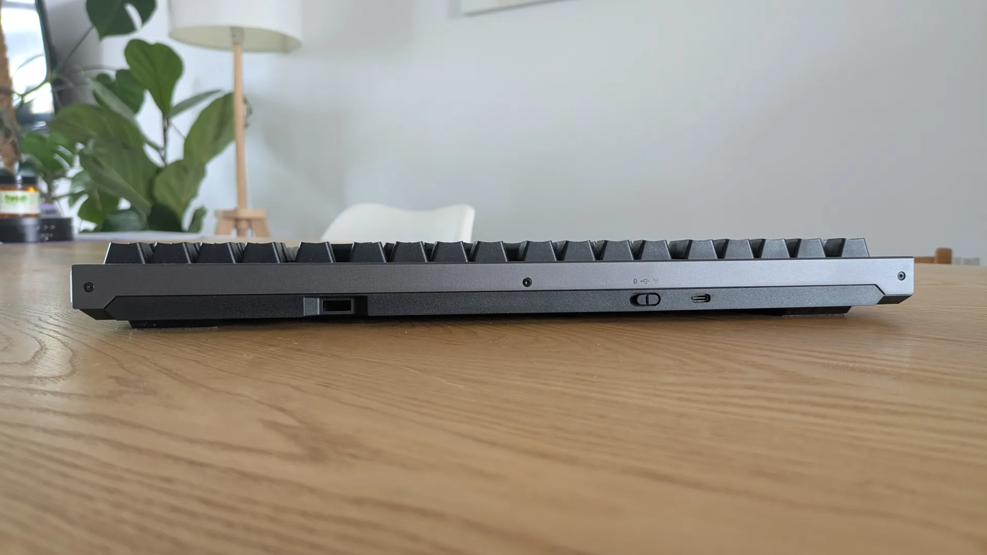 Szczyt klawiatury ASUS ROG Strix Morph 96 z widocznym gniazdem na adapter USB, przełącznikiem łączności oraz gniazdem USB-C do ładowania.