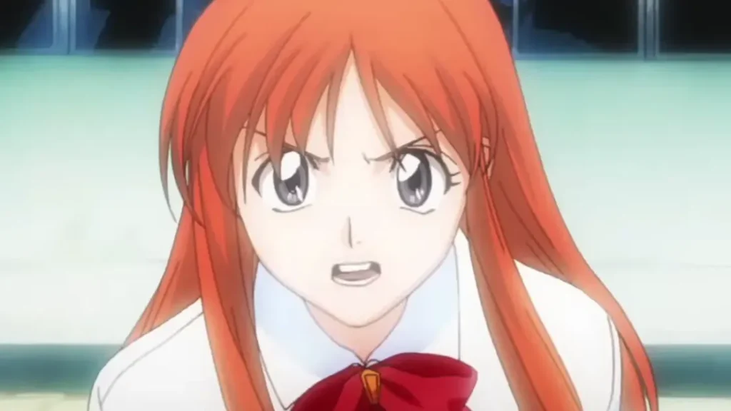 Orihime Inoue w mundurku szkolnym ze zdeterminowanym i zagniewanym wyrazem twarzy.