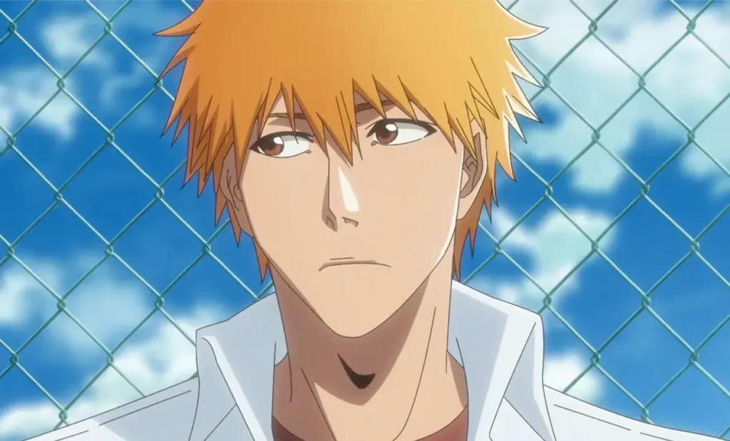Ichigo Kurosaki w szkolnym stroju na tle metalowej siatki i błękitnego nieba.