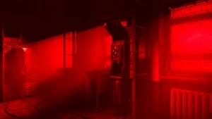 Wnętrze z automatami telefonicznymi w czerwonym świetle w Cronos: The New Dawn.